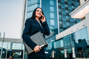 Businesswoman in suit talks by phone outdoor #image_title