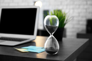 Hourglass on table in office Time management concept #image_title
